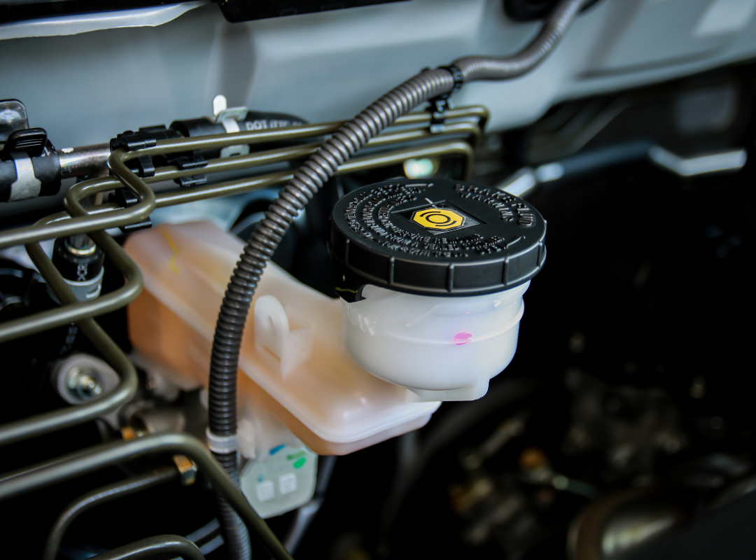 Close-up of a brake fluid reservoir with DOT-rated cap in a vehicle engine bay, brake fluid flush service in Sarasota