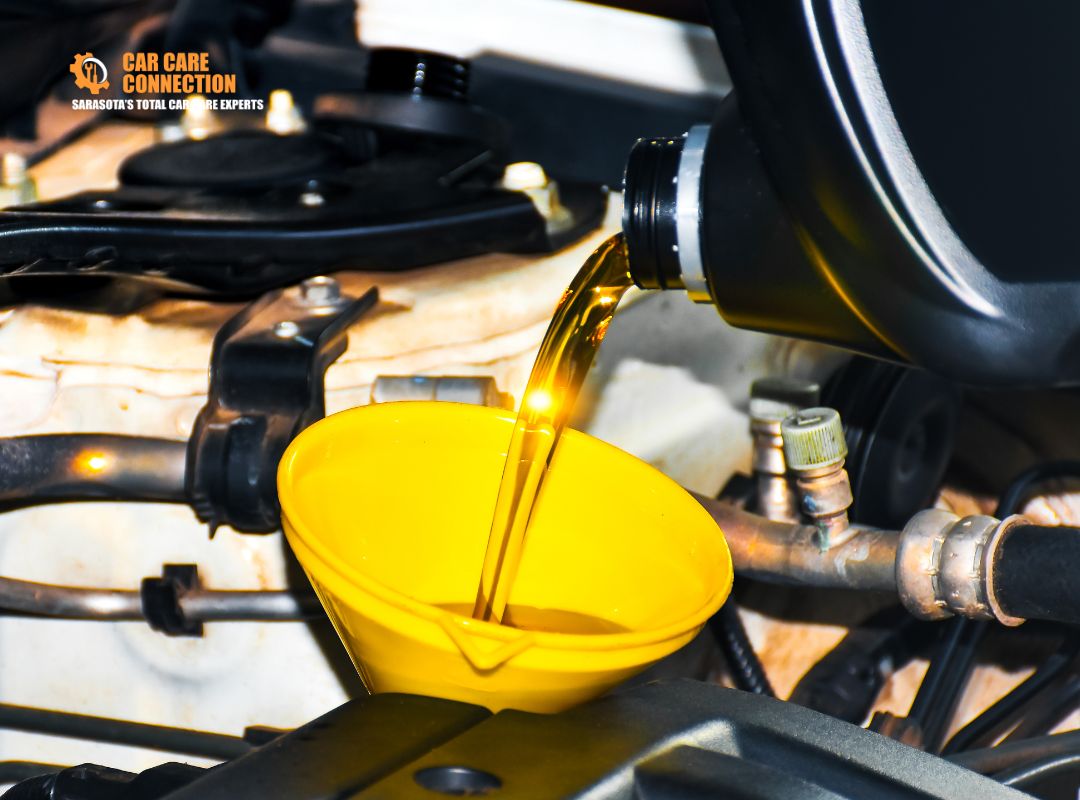Technician pouring fresh engine oil into a vehicle during an oil change service at Car Care Connection in Sarasota