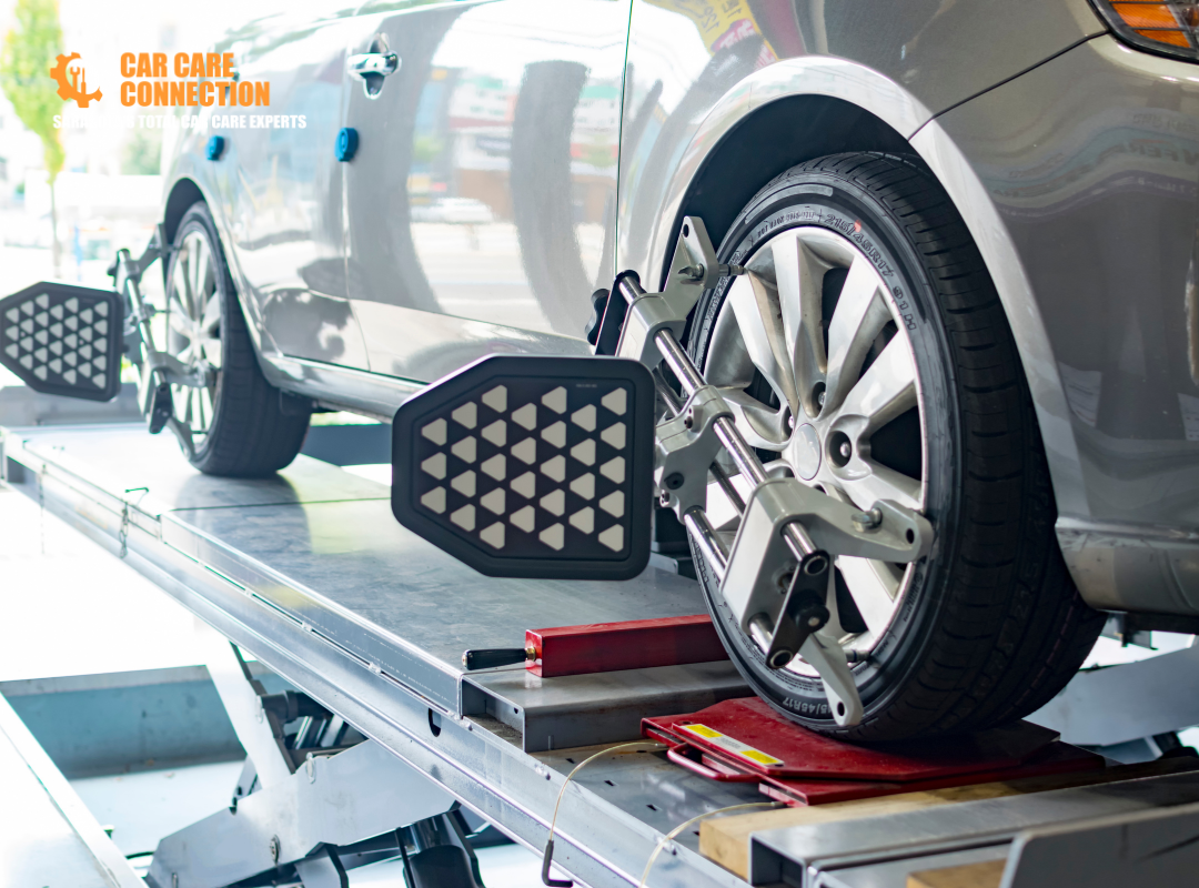 Vehicle on wheel alignment rack with laser measurement equipment attached to wheels at Car Care Connection in Sarasota